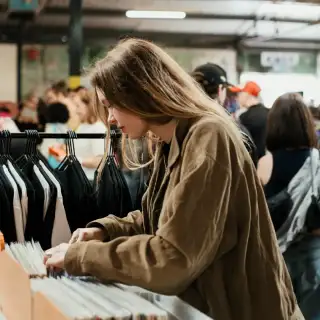 Young person browsing second-hand records at a market